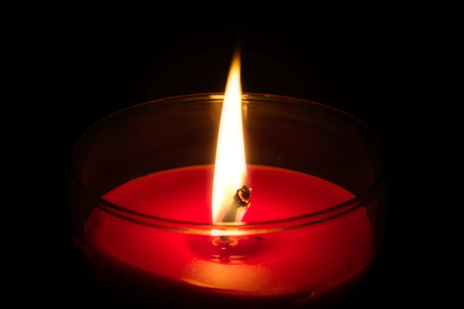 A red candle burning in the dark
