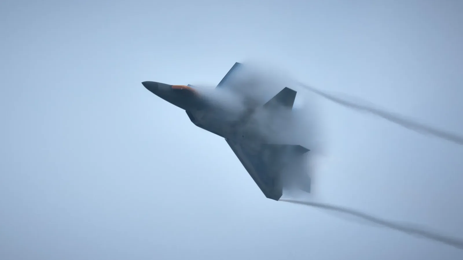 A fighter jet emerging from cloud