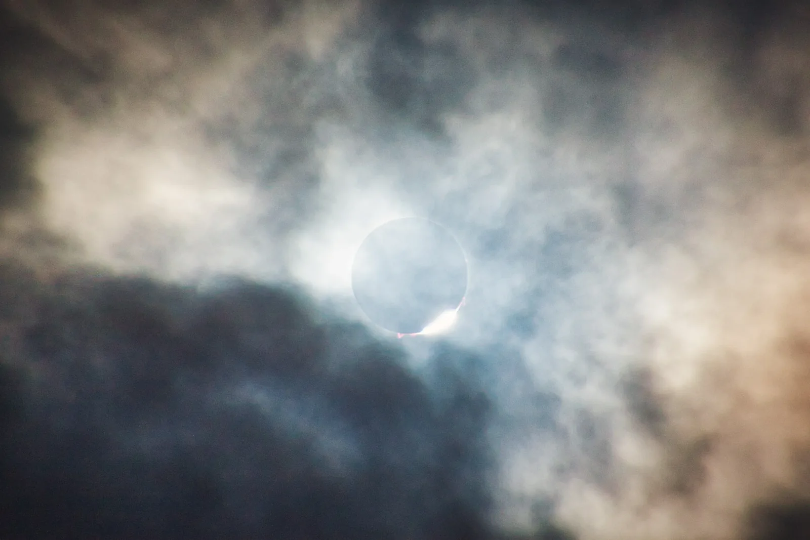 The total solar eclipse breaking through thin cloud