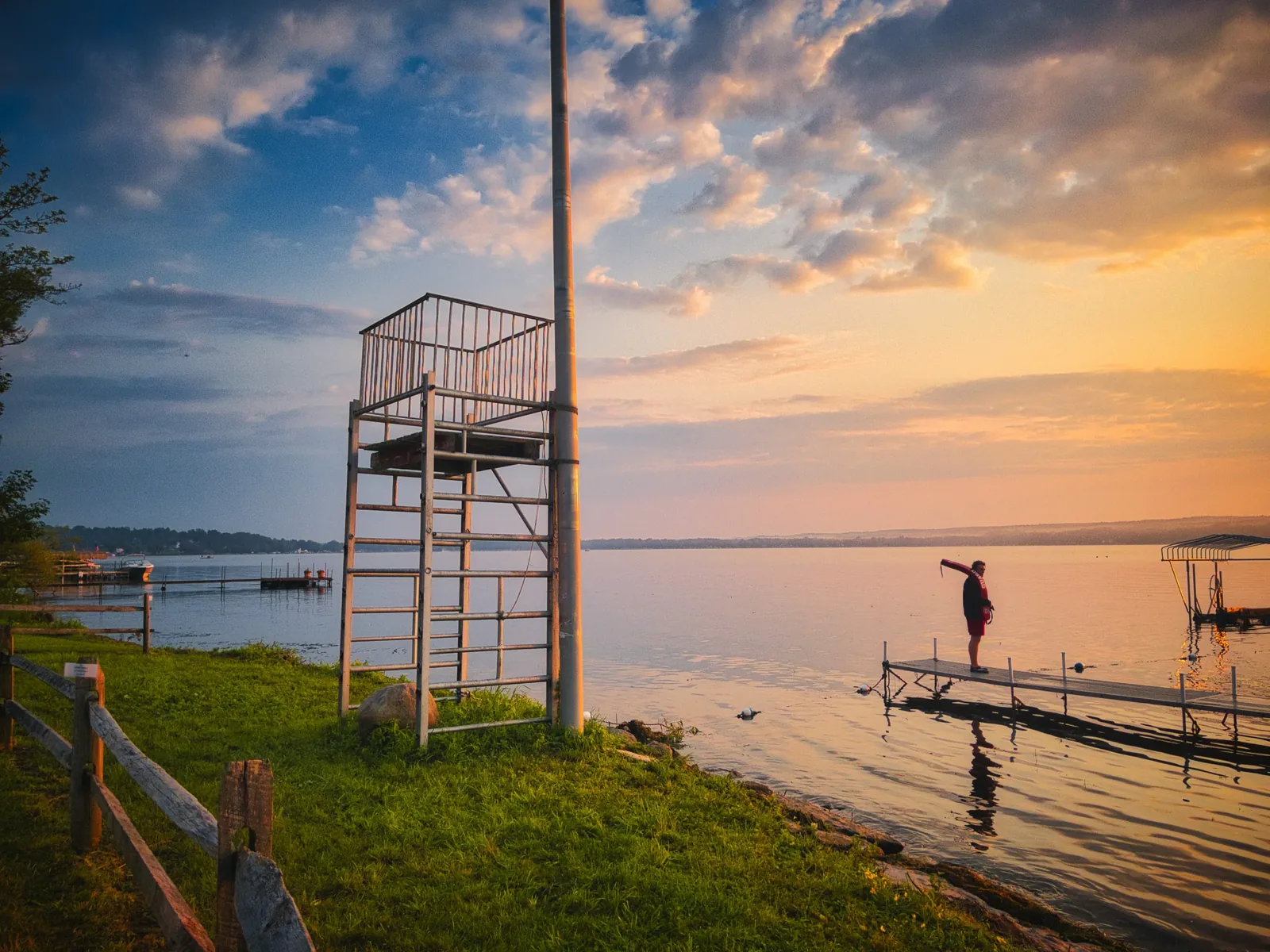 A chair silhouetted by the lake at dusk