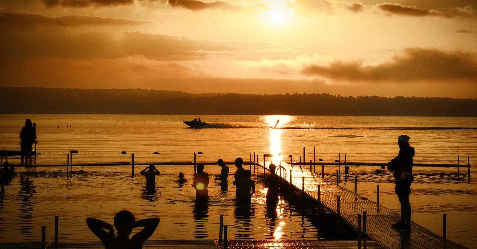 Figures on a pier at golden hour