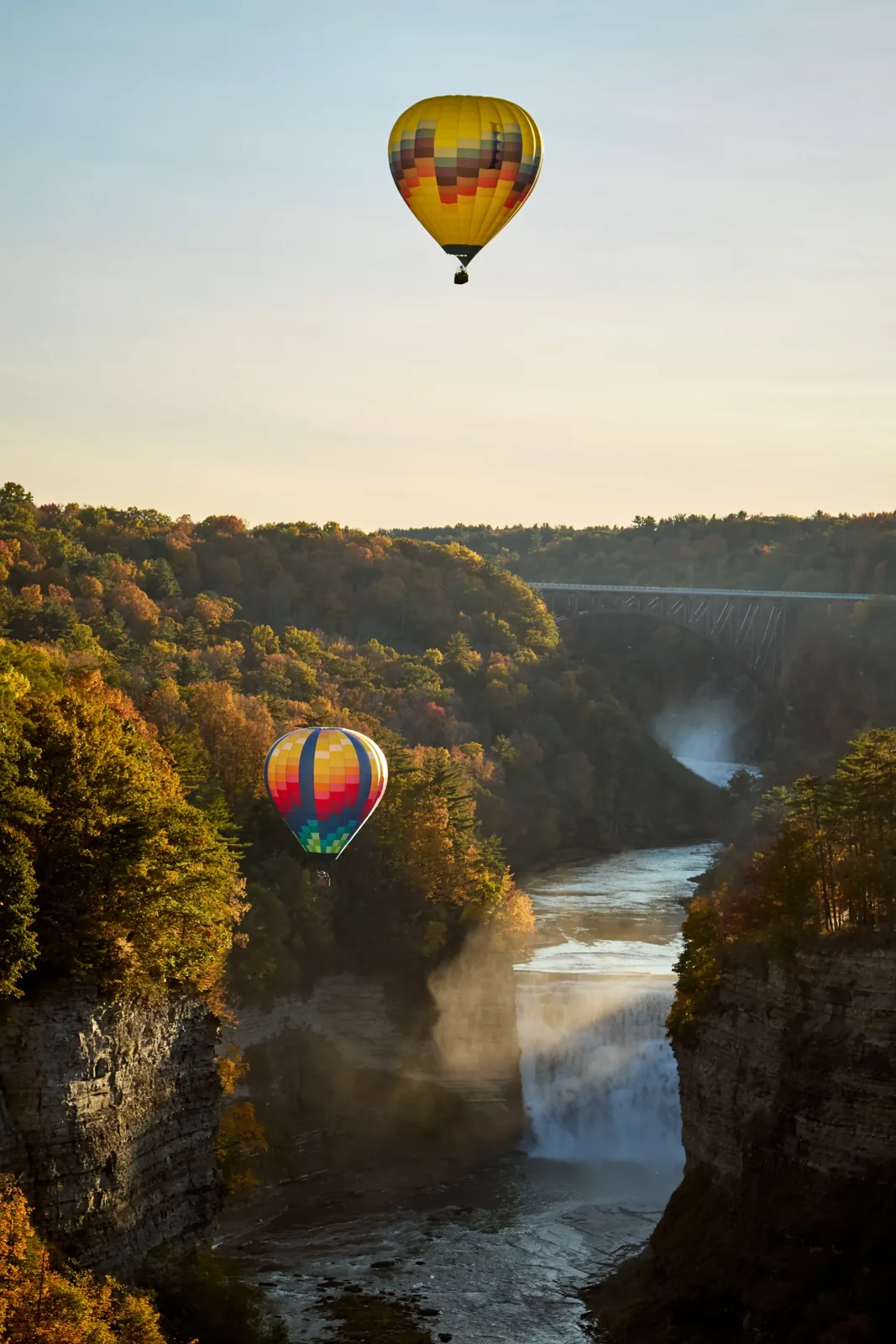 Two hot-air balloons above the Letchworth gorge and its falls in autumn