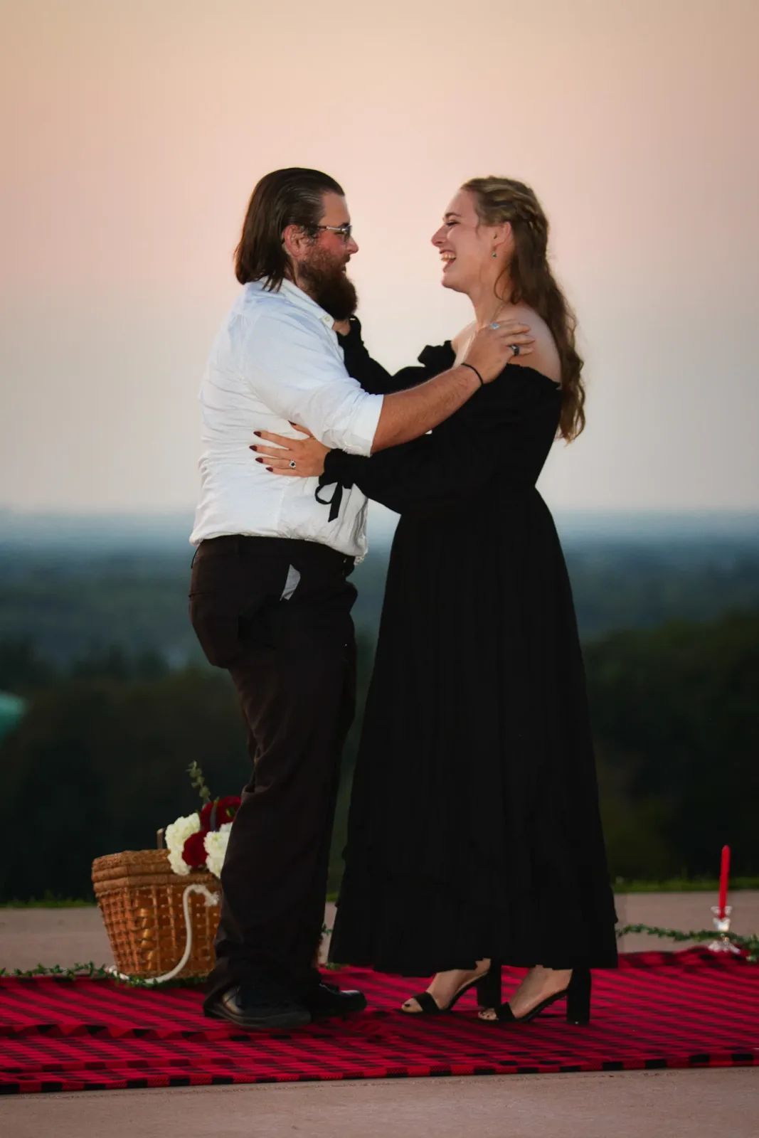 A couple embracing on a hilltop at dusk